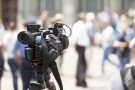 close up of a video camera with a blurred public scene