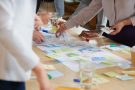 people's hands handling post-it notes on a desk